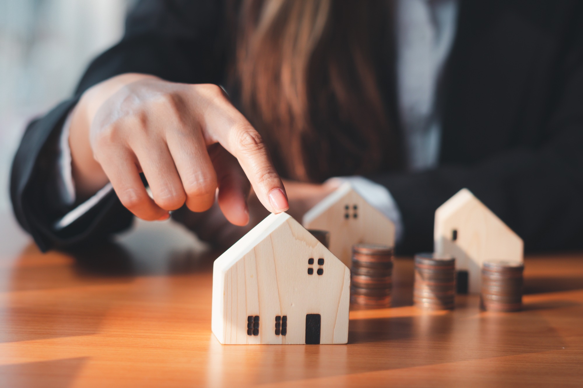 House Model, the Hand of the Businessman Guarding Close Money Saving Ideas to Buy a Home or Loan for Real Estate Investment Planning and Ideas During Saving Can Be Risky.