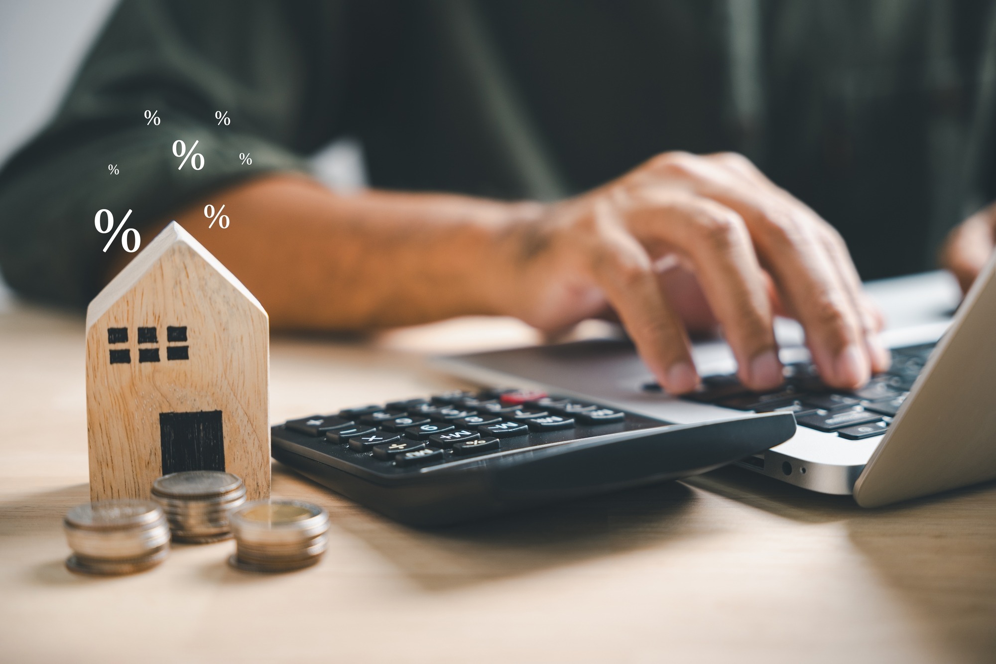 Pressing Calculators, Hand Plans Home Refinance. House Model, Buy or Rent, Calculators on Desk.